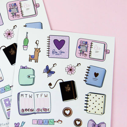 Planner sticker sheet with notebooks, hearts, flowers, bows, and small icons