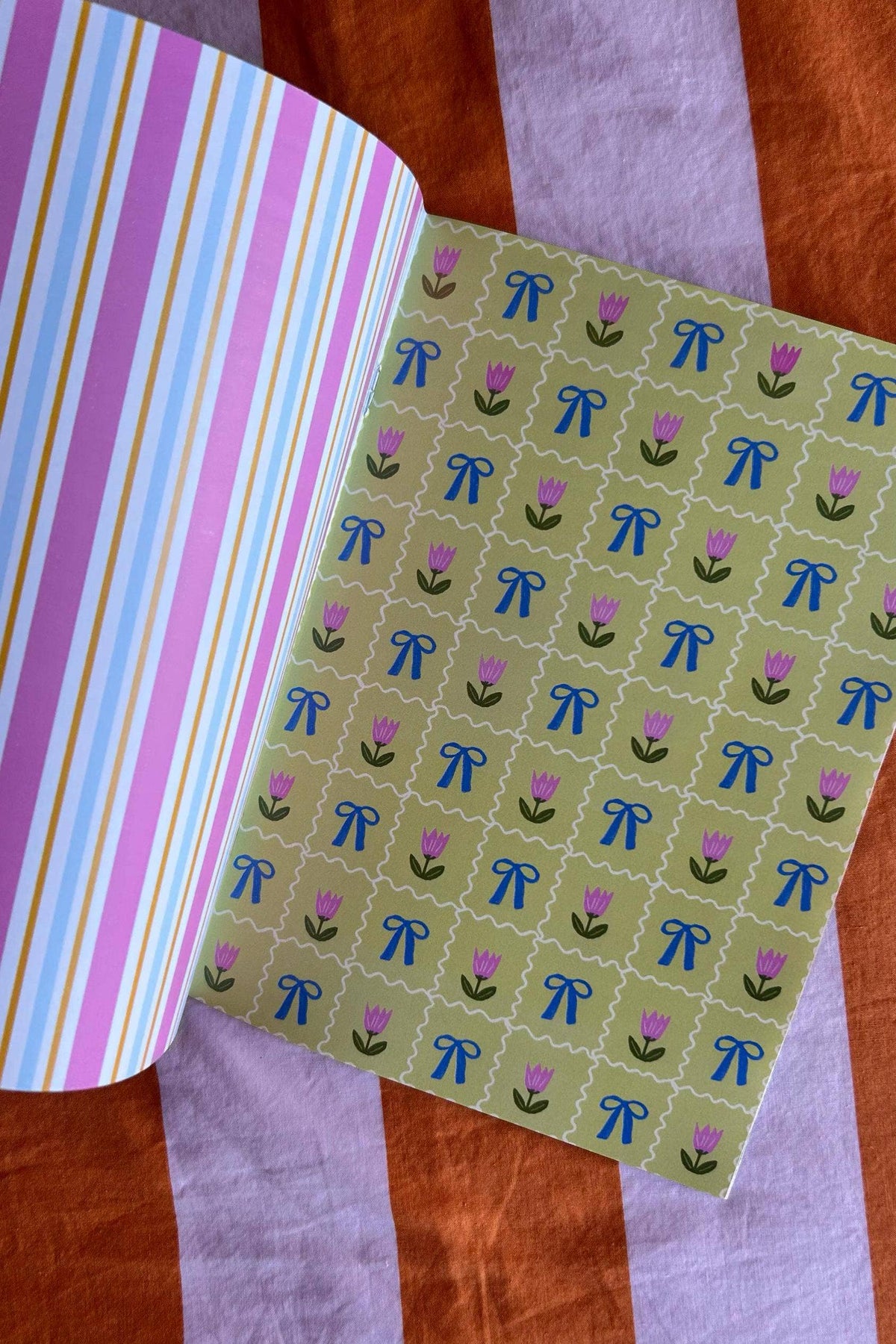 A5 scrapbook paper sheet with green background, purple blooms, and blue bows