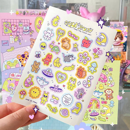 Held mini sticker sheet with pastel cartoon animals, hearts, stars, and SUN PUFF title