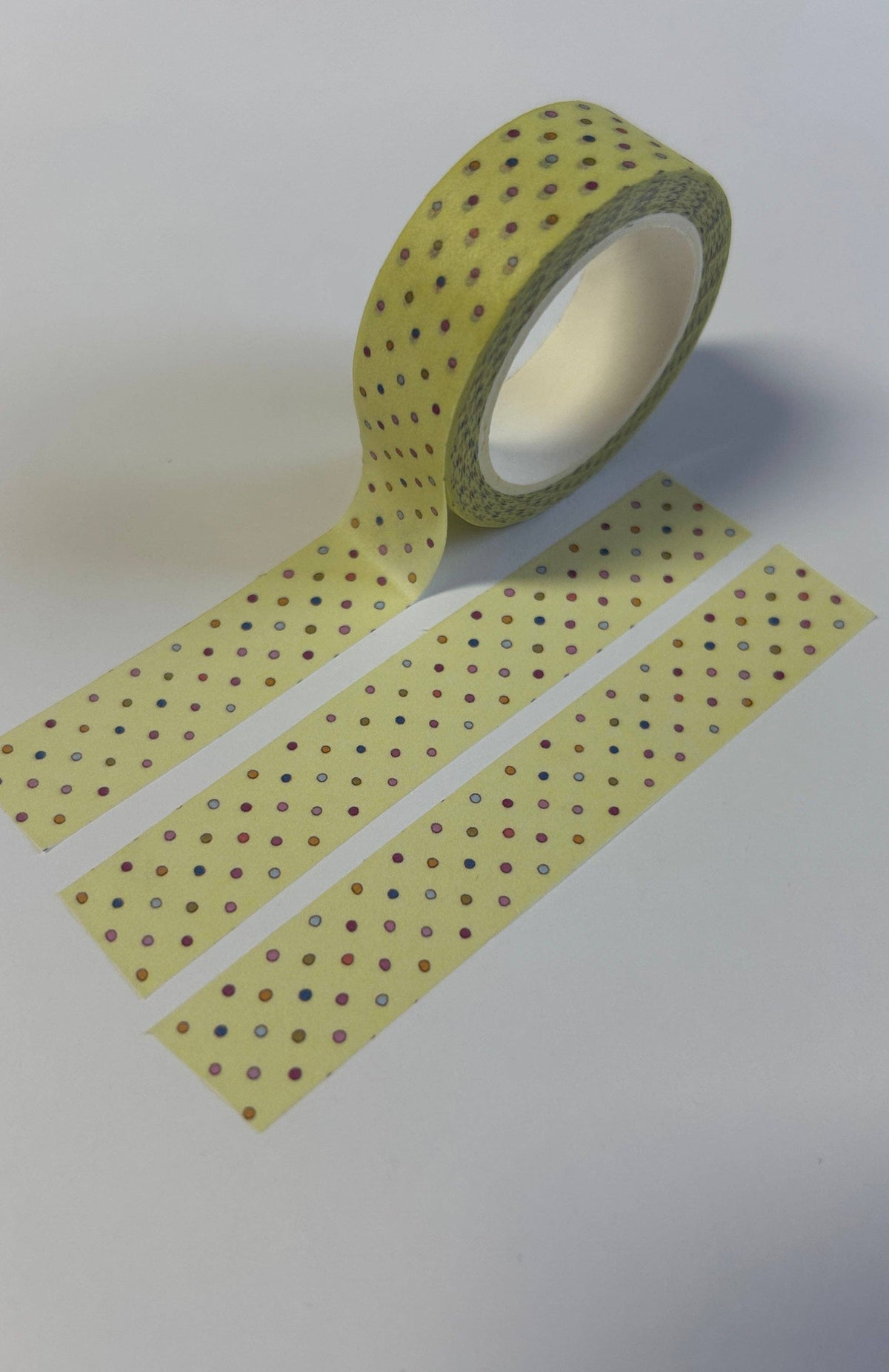 Washi tape spool with yellow tape and dark polka-dot pattern
