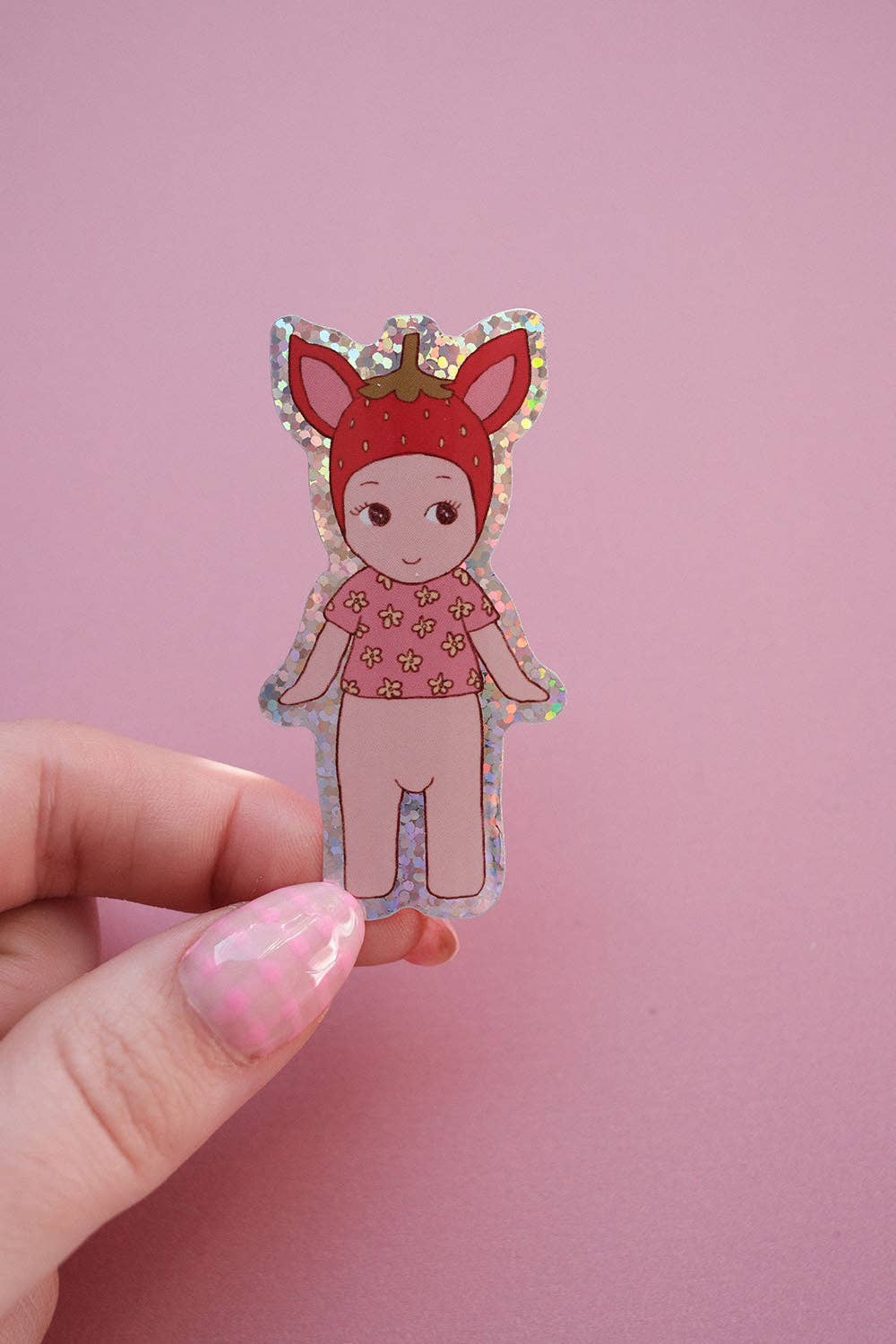 Strawberry baby sticker held in hand, red hood and pink dress