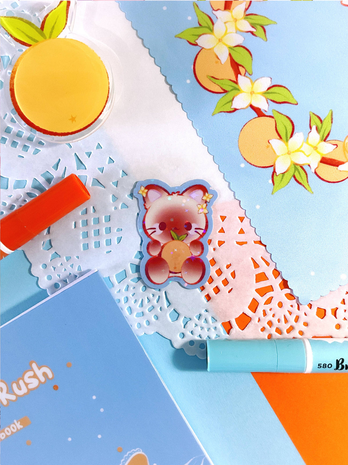 Holographic sticker with orange circle, bear, and yellow floral accents