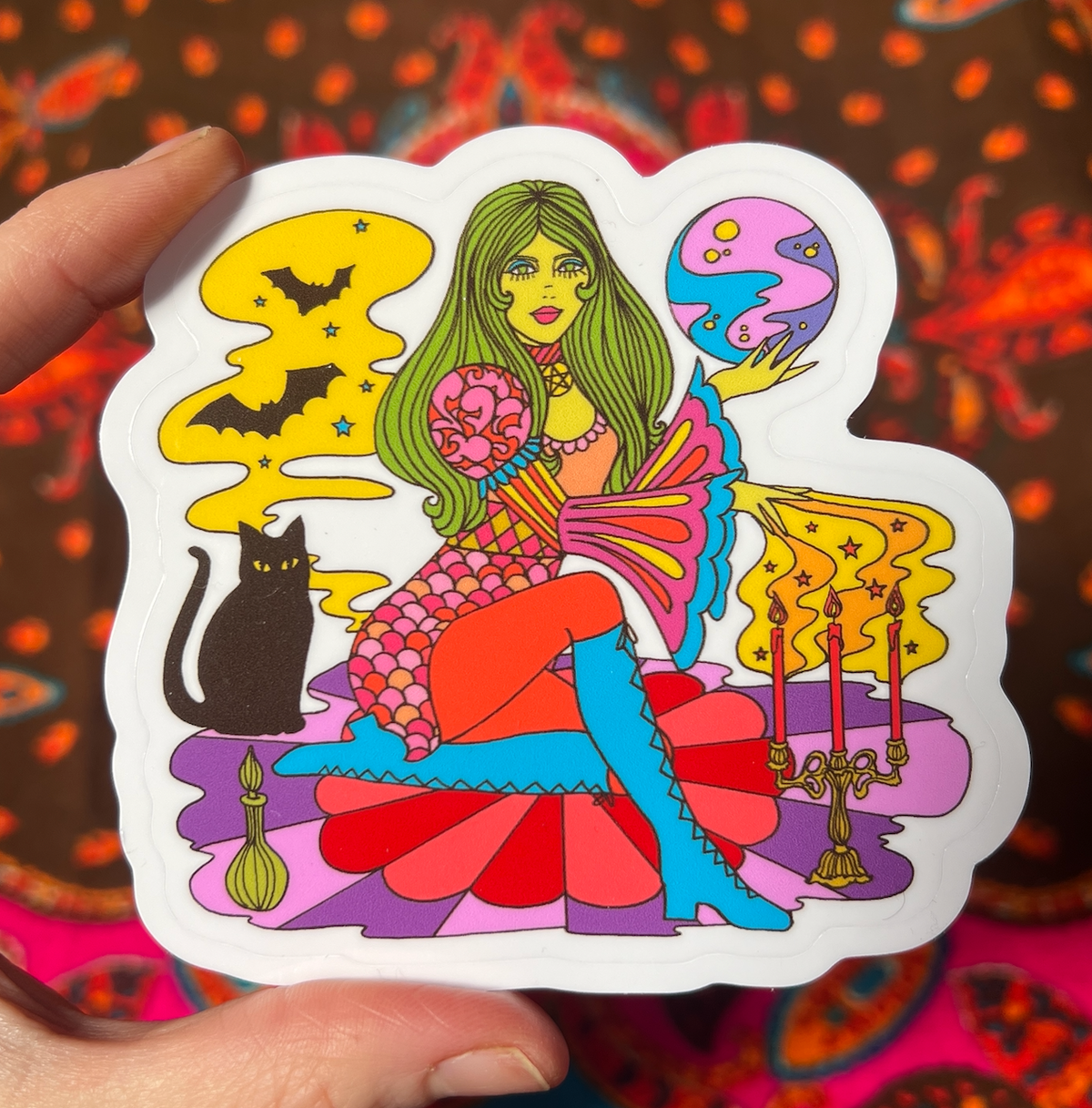 Colorful witch figure sticker with potion moon, white outline, held upright