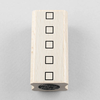Wooden stamp block with four stacked square checkbox outlines
