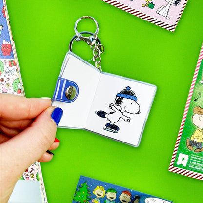 Rectangular mini sticker book keychain open, Snoopy illustration page and metal key rings
