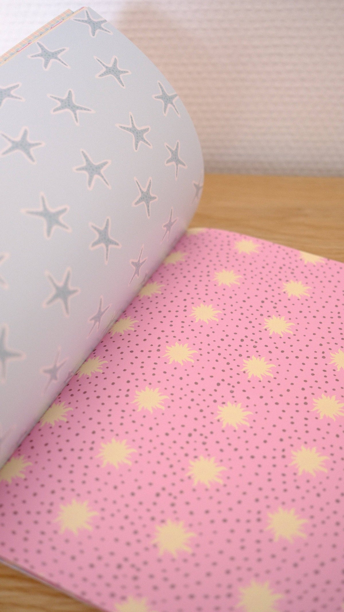 Scrapbook paper set with pale star pattern sheet and pink sunburst dot sheet