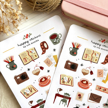 Two sticker sheets with coffee, books, camera, utensils and heart icons