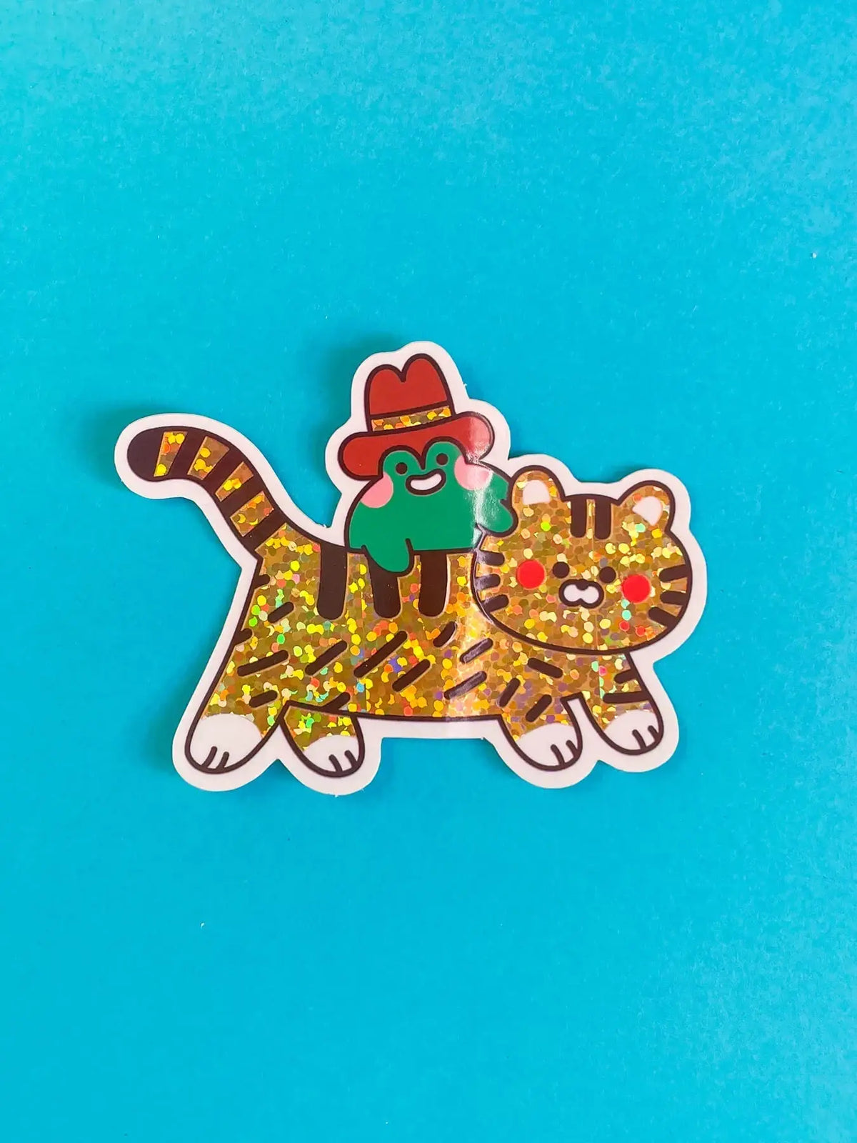 Vinyl tiger sticker with green cap and red collar, gold speckled pattern, white outline