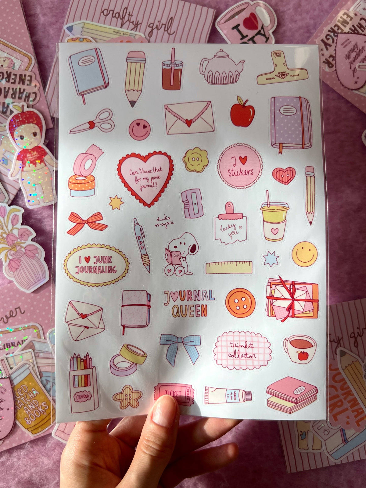 Held sticker sheet with journal queen hearts, envelopes, pencils, coffee cups, bows