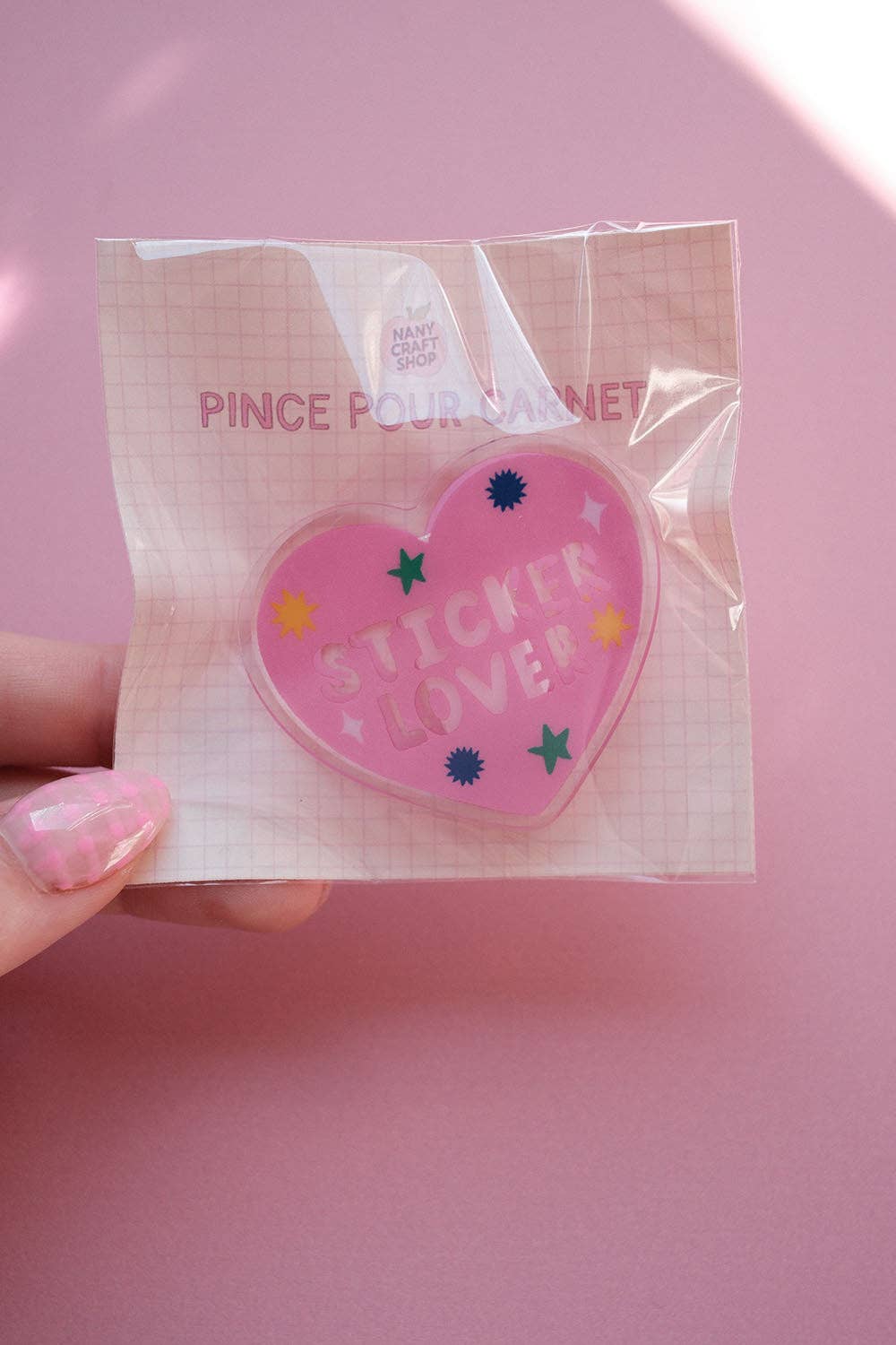 Heart-shaped notebook clip in clear wrapper with pink “Sticker Lover” logo