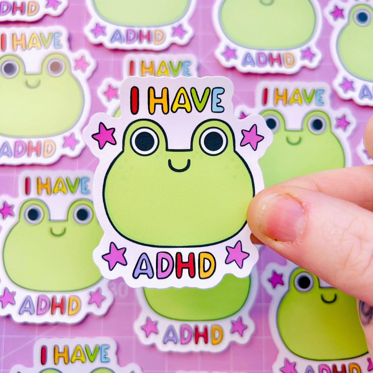 Vinyl sticker featuring a green frog face with eyes, smile, and “I HAVE ADHD” text