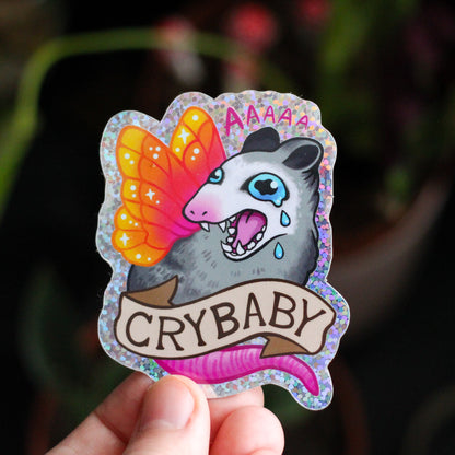 Vinyl sticker: cartoon panda with butterfly wings and 'CRYBABY' text, held by hand