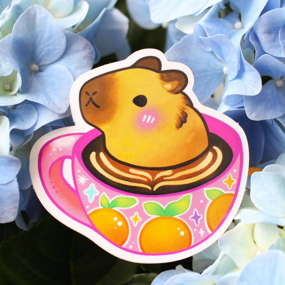 Vinyl sticker of cute capybara face in hot drink cup, pink accents and sparkles