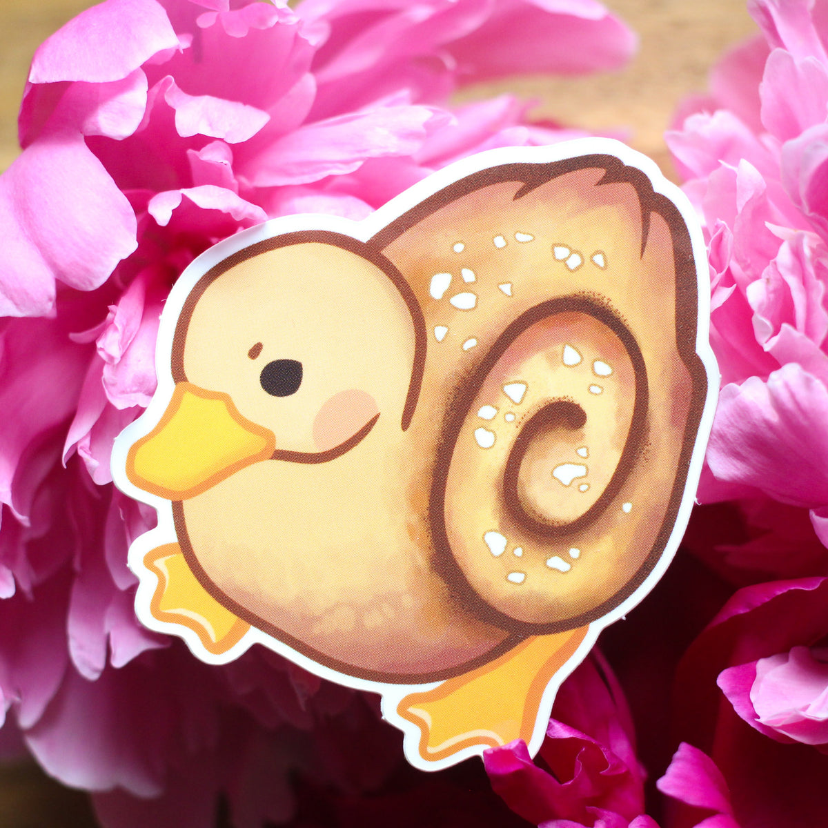 Vinyl sticker of a cartoon duck with a brown donut and white sprinkles