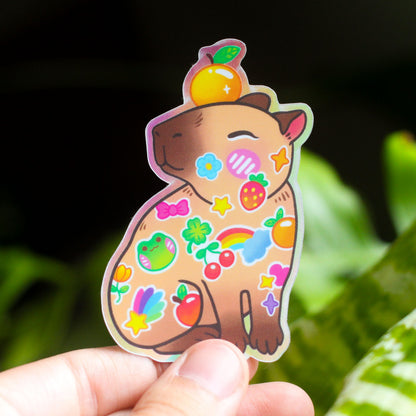Vinyl sticker of cartoon brown animal with colorful icons and cute hat