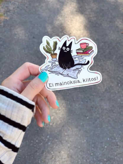 Vinyl cat sticker showing black cat with books, red mug, and potted plant