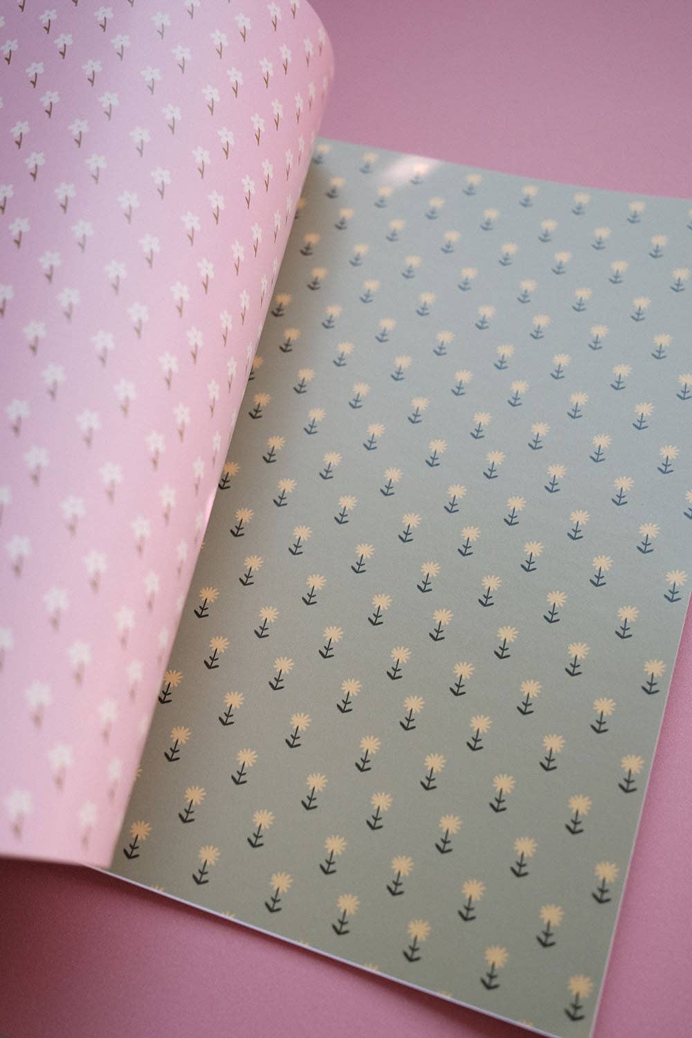Open scrapbook papers: pale pink tiny flowers on left, light blue sprig pattern on right