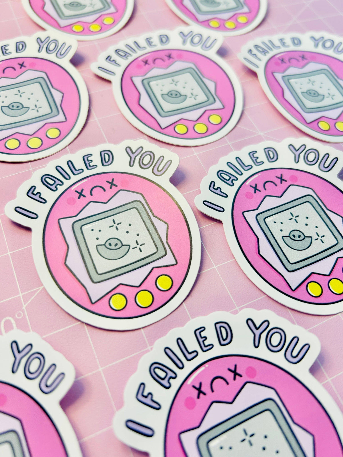 Vinyl sticker sheet with multiple pink “FAILED YOU” game console characters