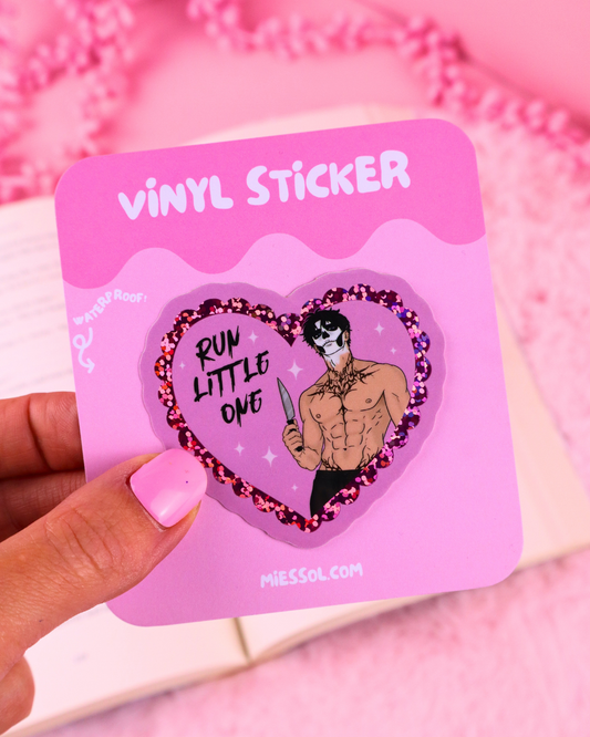 Heart-shaped vinyl glitter sticker with 'RUN LITTLE ONE' and character