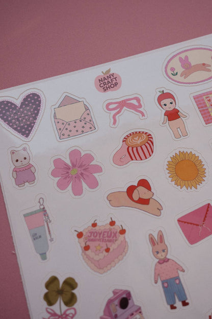 A5 sticker sheet close-up with hearts, bunny, flowers, envelopes, bows, and a sunflower