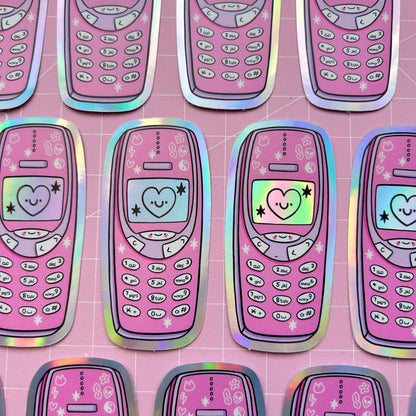Row of holographic phone-shaped stickers in pink with hearts, stars, and keypad graphics