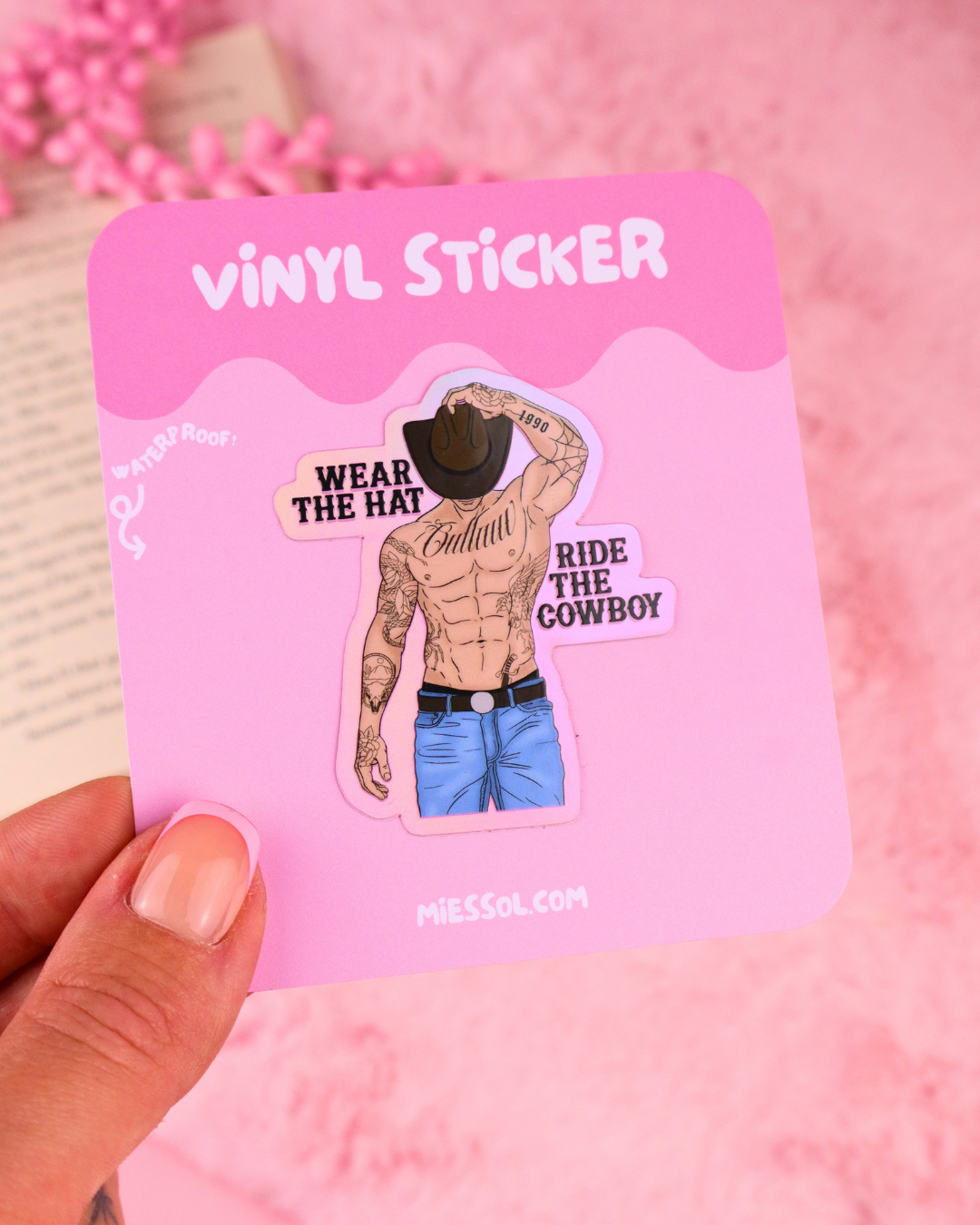 Pink vinyl sticker card showing cowboy wearing hat with text 'Wear the Hat' 'Ride the Cowboy'.