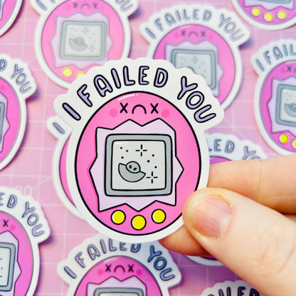 Single vinyl sticker held by fingers, pink “FAILED YOU” game console icon