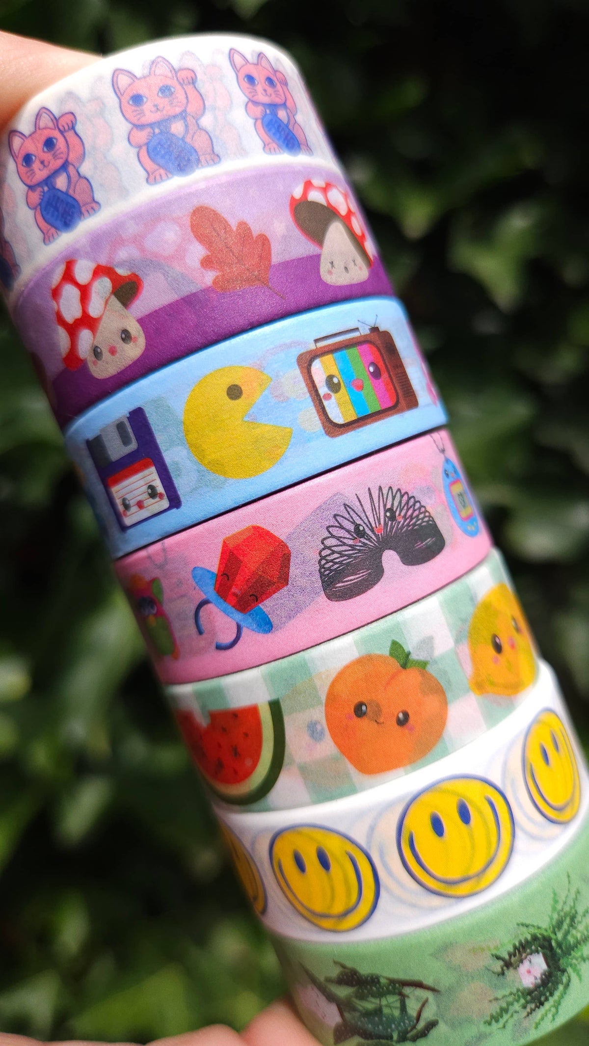 Washi tape roll with mixed icons: cats, fruits, butterflies, and smiley faces