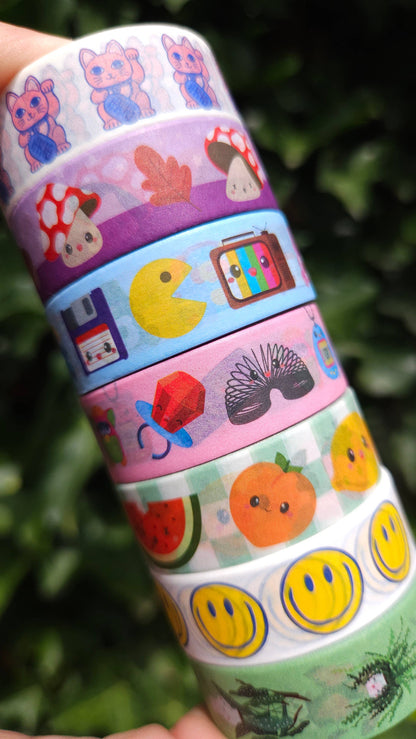 Washi tape roll with mixed icons: cats, fruits, butterflies, and smiley faces