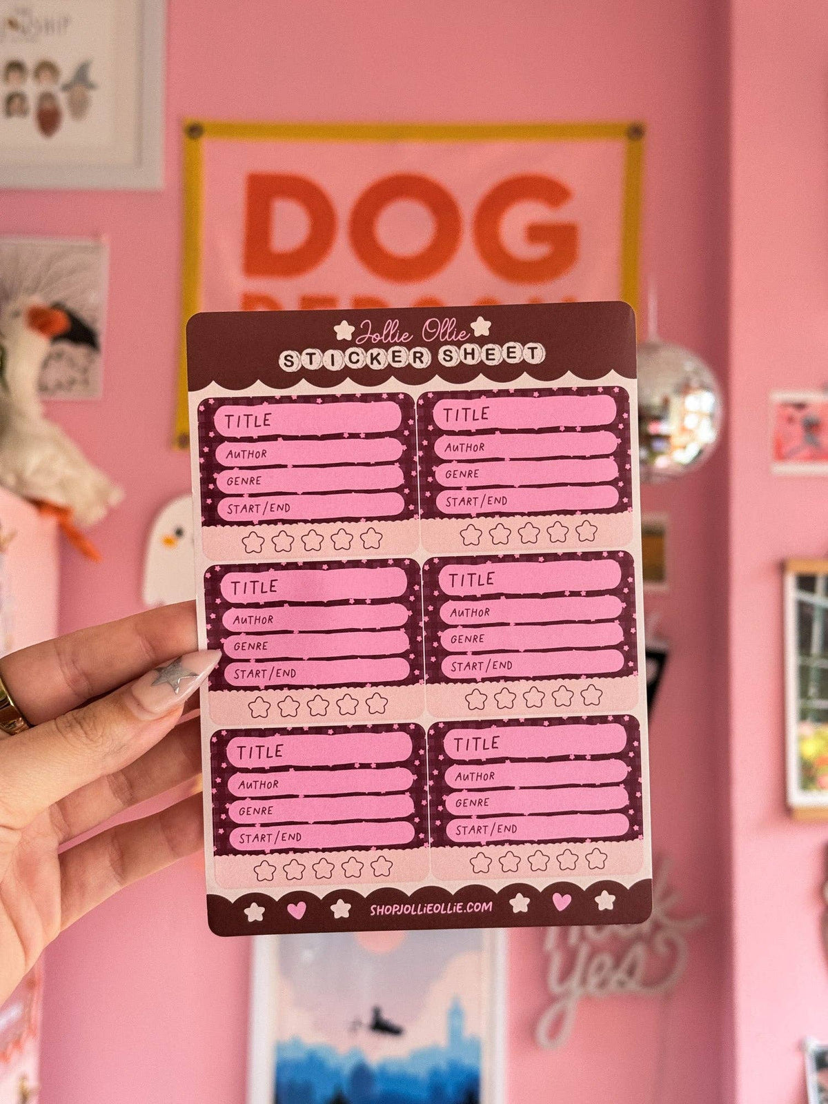 Maroon book review sticker sheet with scalloped label boxes; held in hand