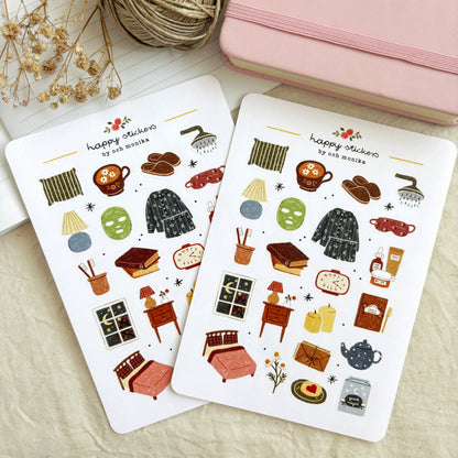 Bedtime sticker sheets laid open, featuring pajamas, teapot, books, and drinks