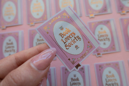 Vinyl sticker with pink frame and gold "Book Lover's Society" lettering