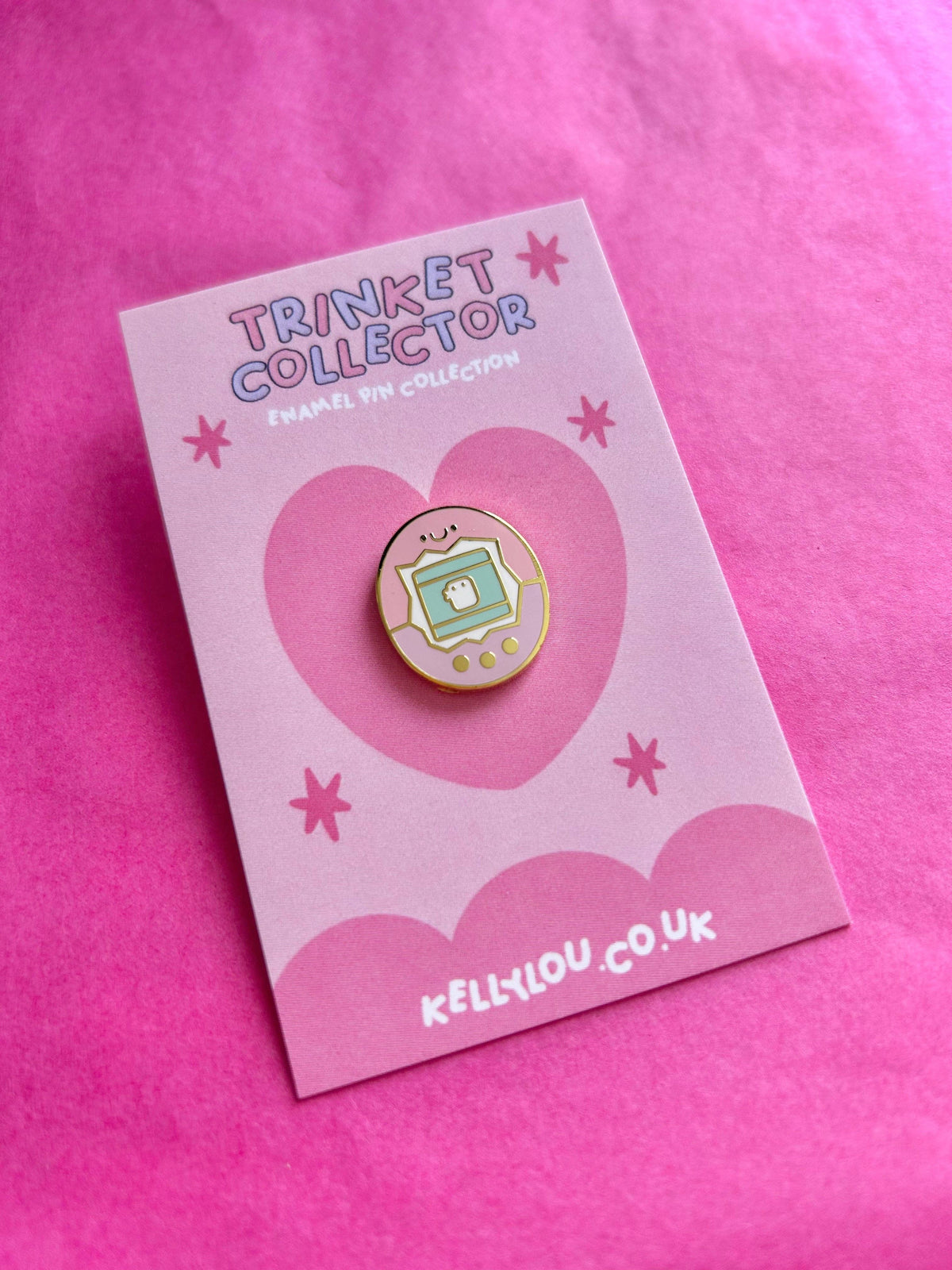 Round mini enamel pin showing a smiling device-style virtual pet on a card.