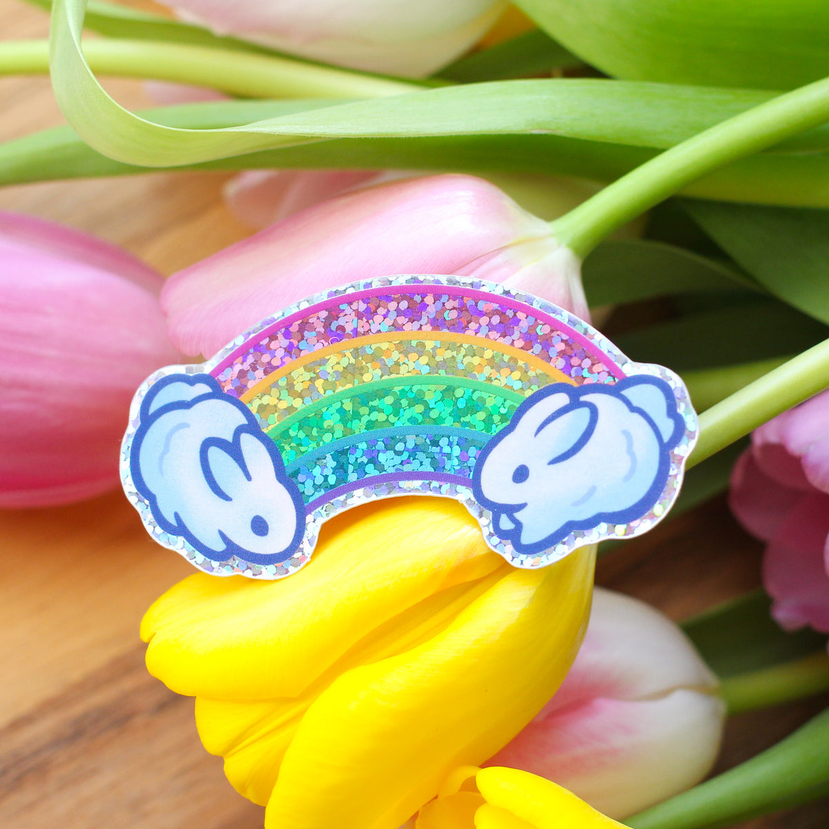 Rainbow bunny glitter sticker with arched rainbow and blue bunny head accents
