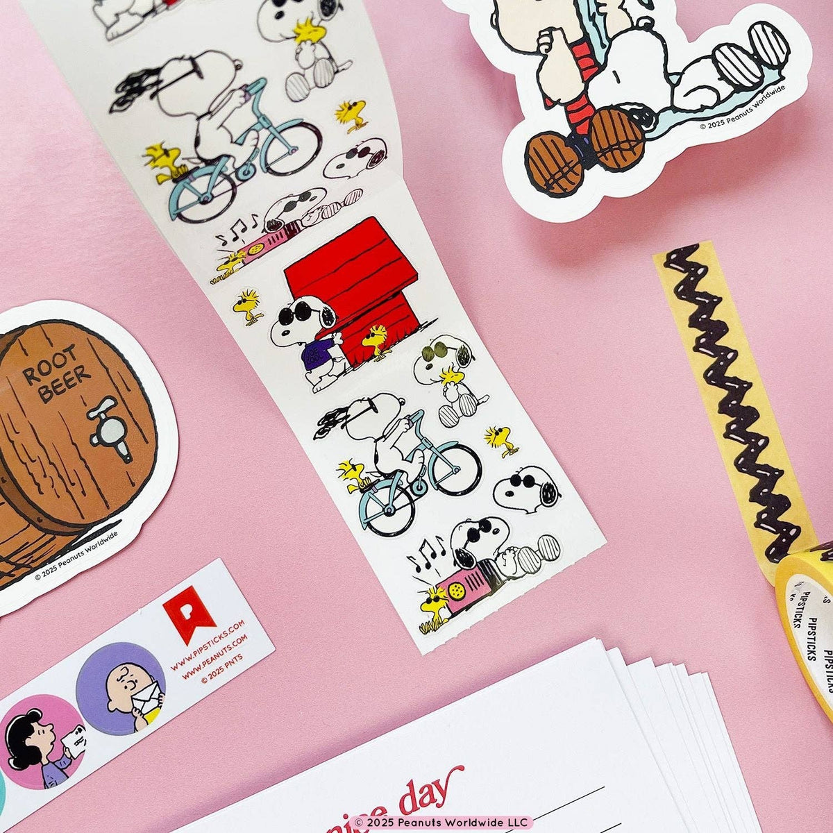 Snoopy and Woodstock sticker roll with colorful character decals, bikes and music notes