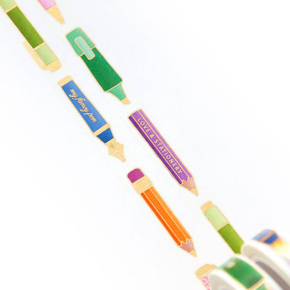 Washi tape roll with pen-themed strips in green, blue, orange, and purple