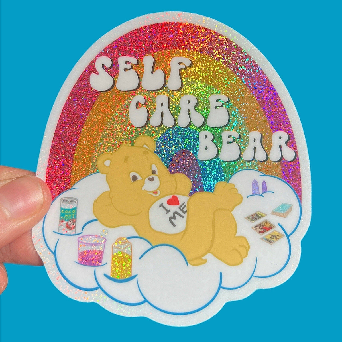 3-inch glitter sticker with Self Care Bear on clouds, rainbow heart and bright border