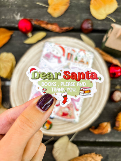 Hand holding 'Dear Santa Books, Please' vinyl sticker with red text and Santa illustration