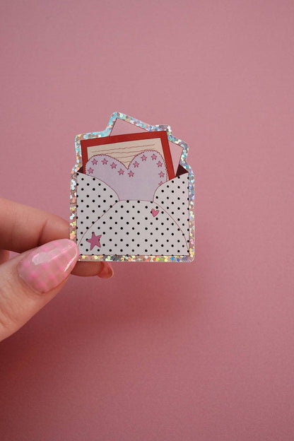 Small mail envelope sticker showing polka dots, stars, and a red inner flap