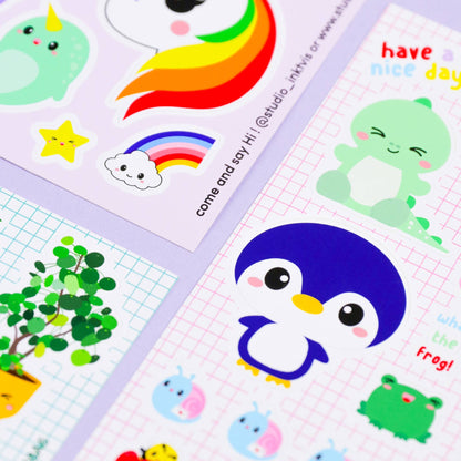 Sticker sheet close-up with rainbow trail, green octopus, cloud, star, and penguin head