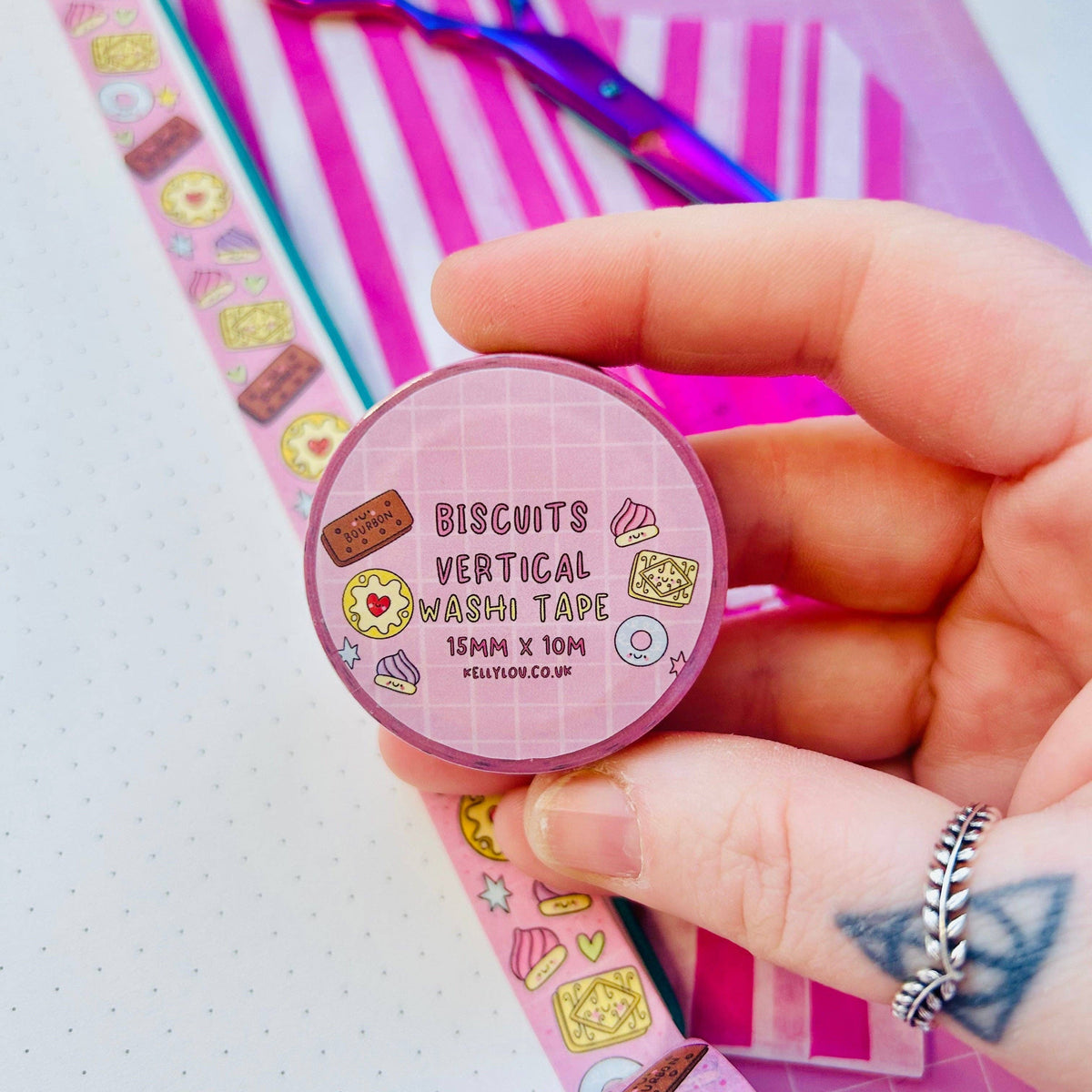 Pastel vertical washi tape roll with biscuit icons, held in hand