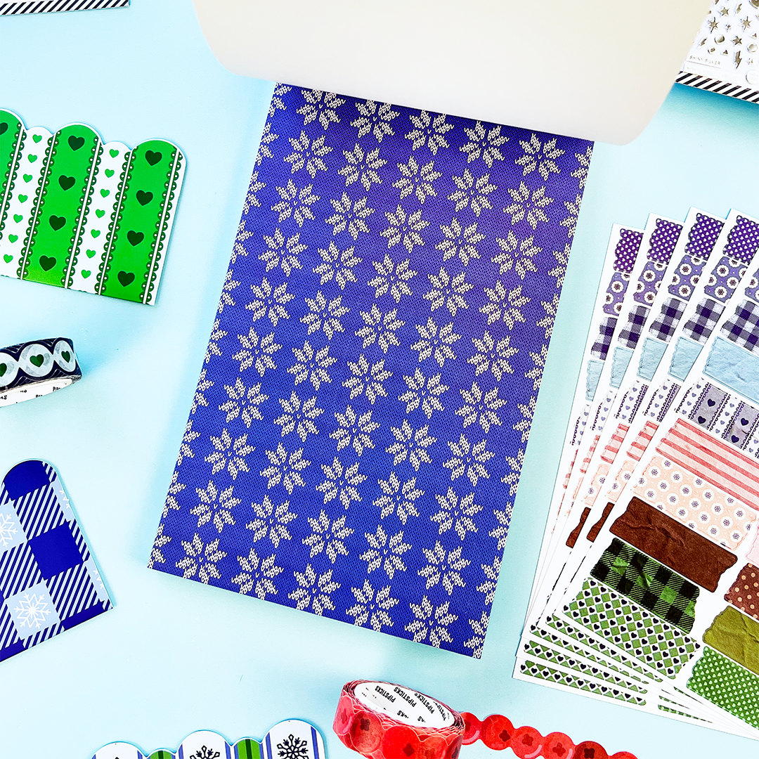 Blue winter sticker sheet with repeating white snowflake pattern and assorted cutout stickers
