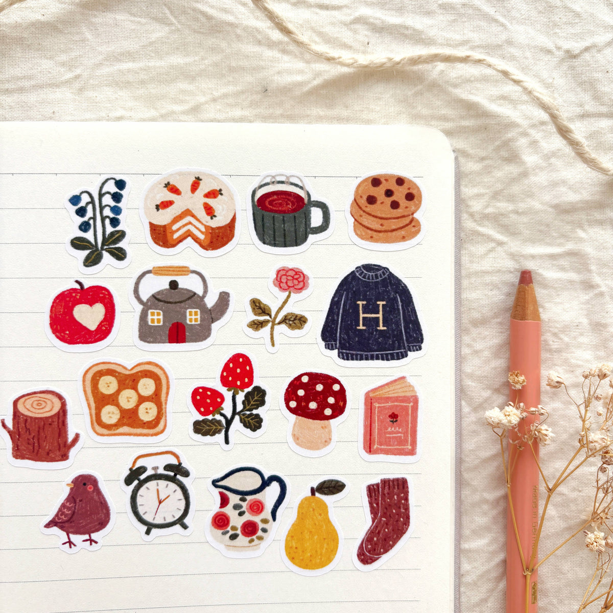 Sticker sheet detail with tea kettle, cookies, heart, mushrooms, socks, and bird