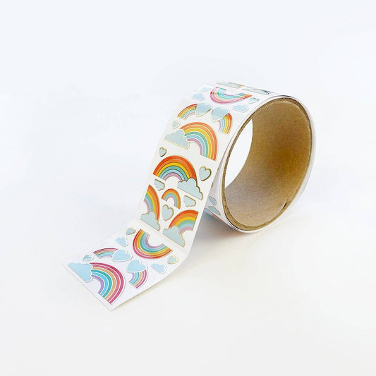 Rainbow sticker roll with rainbow arcs, clouds, and heart icons on a paper strip