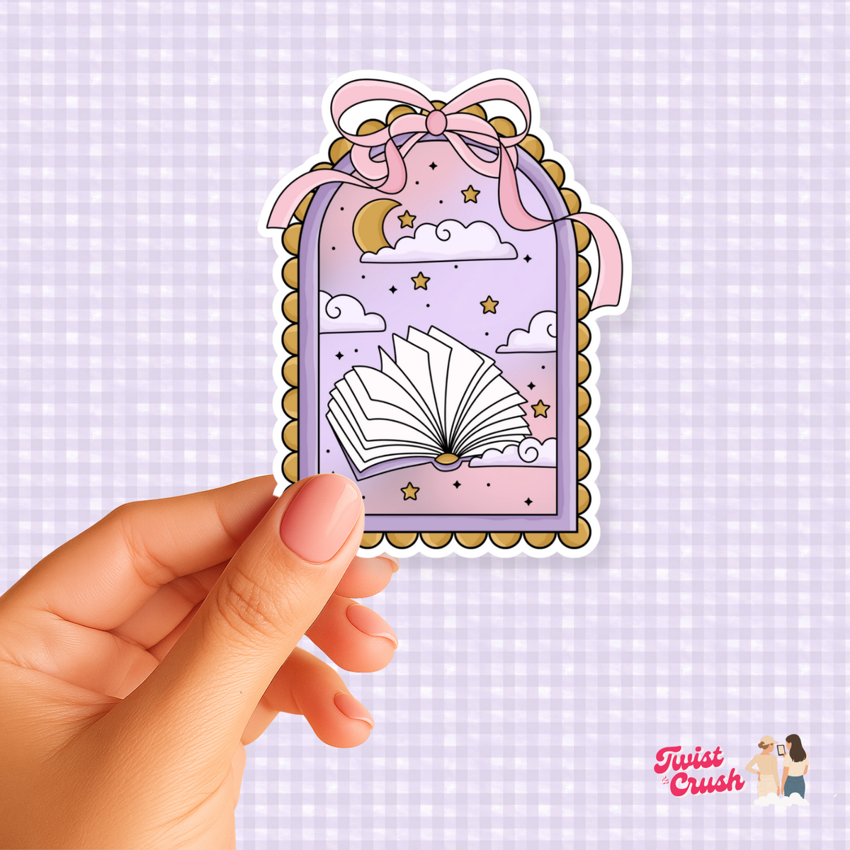 Book-shaped sticker with open-book illustration, stars, and bow; held by hand