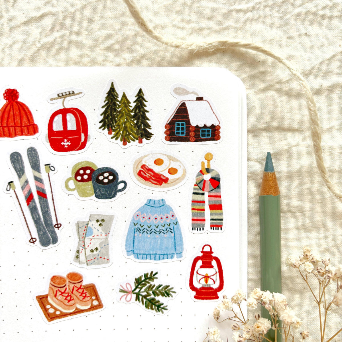 Close-up sticker sheet with cabin, trees, kettle, scarf, skis, and lantern icons