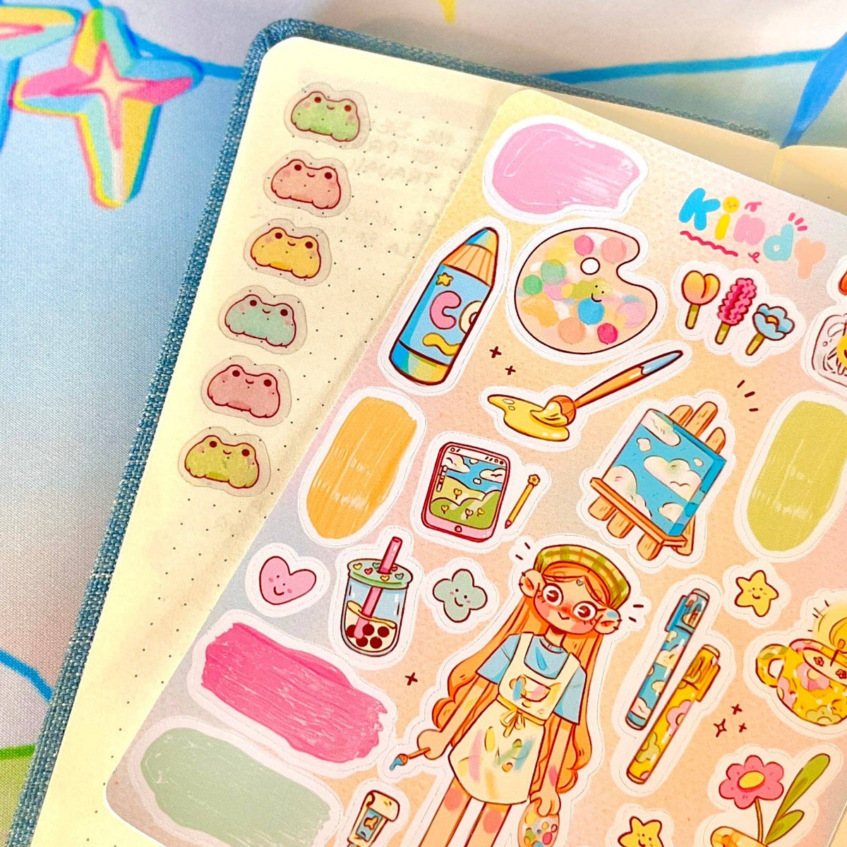 Sticker sheet corner with cartoon paints, palette, brushes, and doodled hearts
