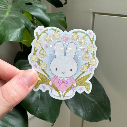 Bunny flower sticker featuring pale blue bunny face, pink bow, and springlike flowers