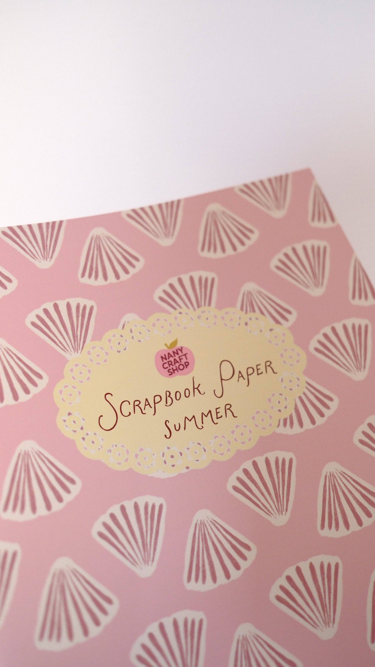 Scrapbook paper sheet with seashell fan print and “Scrapbook Paper Summer” label