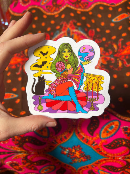 Colorful witch tarot sticker with white outline, held by hand at top